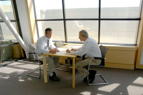 two men talking over a table