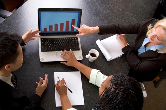 group of people in business attire looking at a laptop